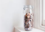 Glass jar of pennies on a windowsill