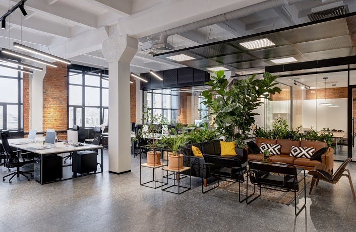modern loft office interior with panoramic windows and a row of dark wood tables