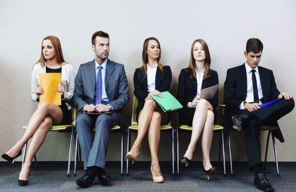 5 people sitting in a row waiting for a job interview