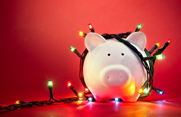 piggy bank with coloured fairy lights on a red background