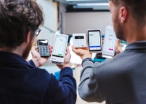 Two people presenting a range of card machine readers