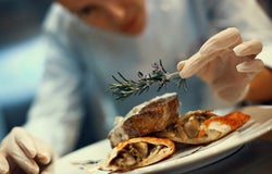 Chef prepares dish in kitchen