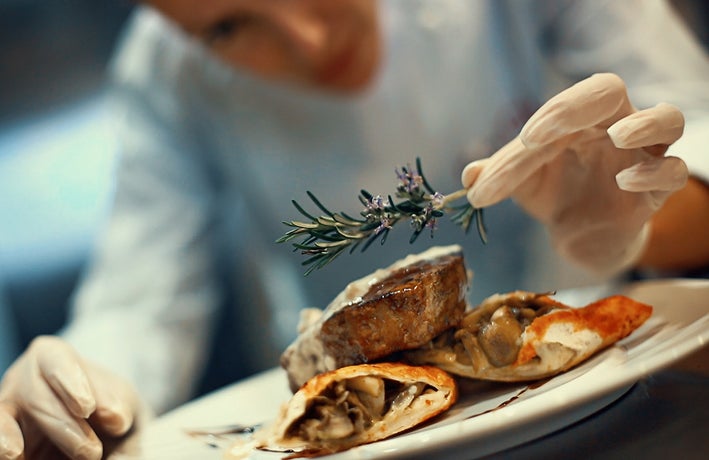 Chef prepares dish in kitchen