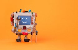 A smiling toy robot on orange background