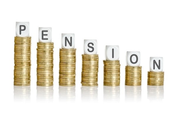 Scrabble letters spelling out Pensions on stacks of coins
