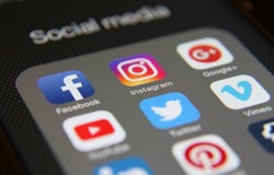 Close up of a mobile app screen showing Facebook Instagram Twitter social media for business