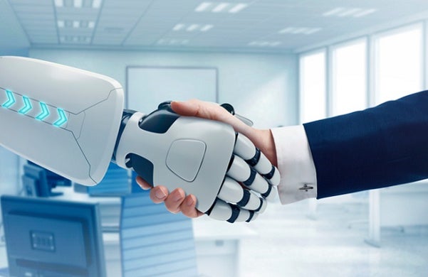 Mid-shot of a robot hand shaking a business man's hand.