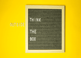 Black square board on a yellow background with the text 