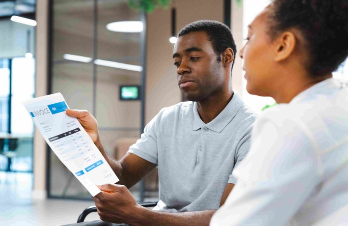 Two people discussing an invoice