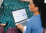 A woman works on accounting on a laptop
