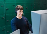 Man smiling while looking at a telephone system