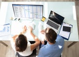 Two Businesspeople Analyzing Gantt Chart On Computer