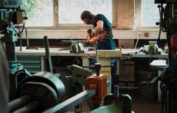 A man using a grinder in a workshop