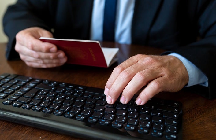 Close up. The immigration control officer verifies passport identification data.