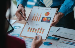 Close up bookkeepers working with balance sheet to analyze problems and find solutions to bringing develop business organization and company's stock market system. Common stock and preferred stock.