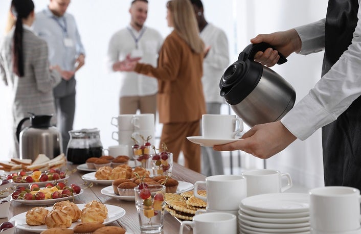 Waitress pouring hot drink during coffee break, closeup