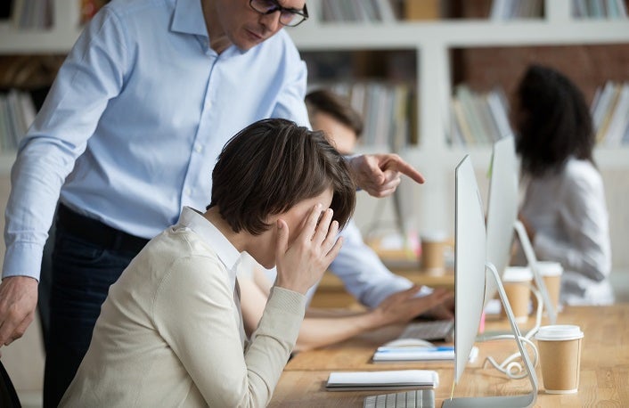 Stressed female employee suffering from discrimination of angry male boss