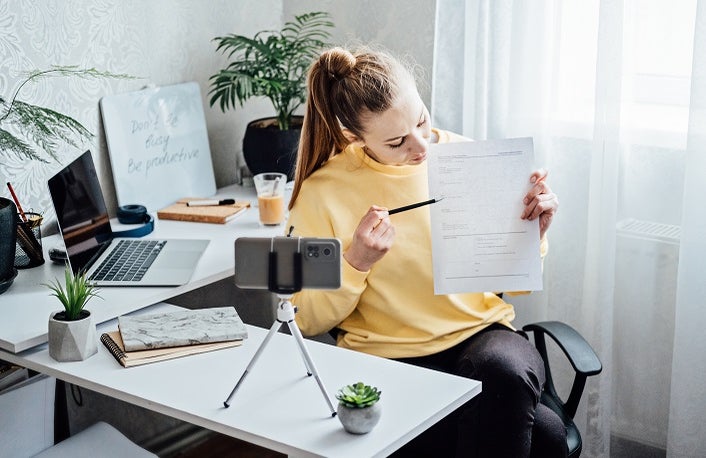 Passive Income, Side Hustle Ideas to Earn at Home. Young woman speaking in front of camera for vlog as blogger, recording video tutorial or training course. Earn extra money, money making.