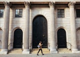 A woman walking past a bank
