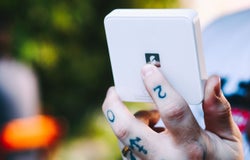 An image of a man holding a SumUp card reader
