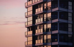 A close-up image of a block of flats at sunset