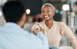 Black, female woman shaking hands with white male to seal an agreement