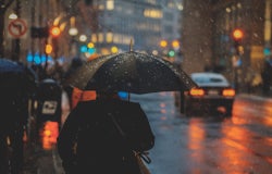 Man on a street in the rain with an umbrella