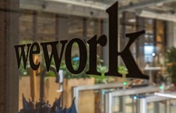 wework lettering on the glass door at night