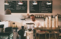 a barista makes a coffee in a shop