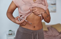 woman making hormonal injections in belly, tattoo, pregnancy concept