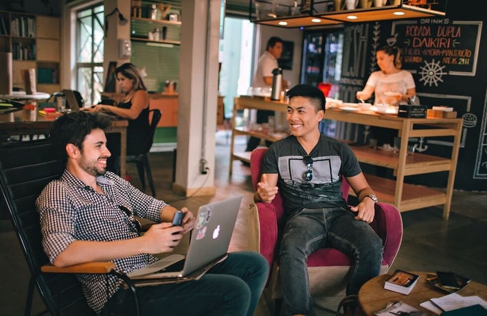 modern workplace with colleagues sitting alongside each other and a bar in the back