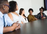 a group of businesswomen speaking at a table