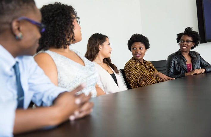 a group of businesswomen speaking at a table