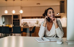 Smiling woman, dressed casually, having phone call.