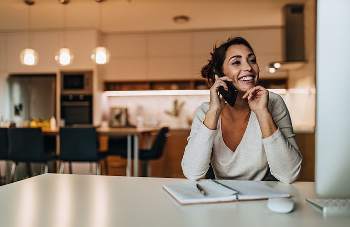 Smiling woman, dressed casually, having phone call.