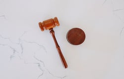 a top-down image of a gavel on a marble worktop
