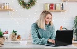 Business woman working at home on laptop during Christmas and New Year, happy and successful completes a big project