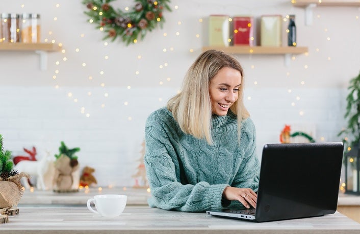 Business woman working at home on laptop during Christmas and New Year, happy and successful completes a big project