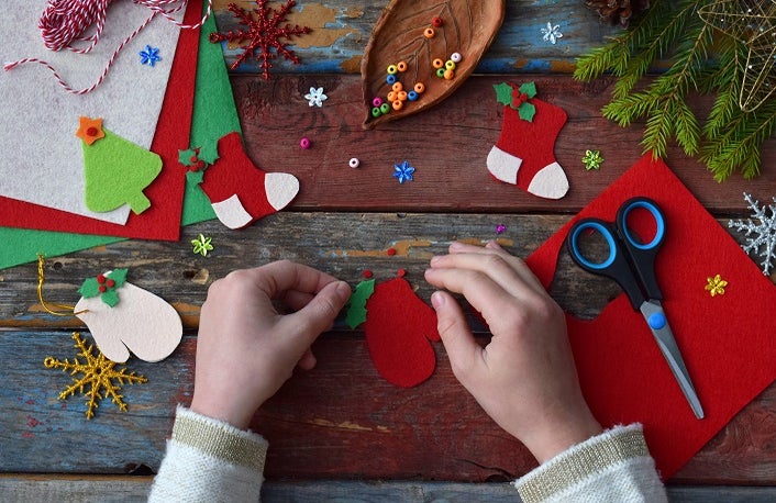 Making of handmade christmas toys from felt with your own hands. Children's DIY concept. Making xmas tree decoration or greeting card. Step 3. Decorate the toy.