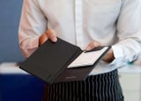 Waitress holding out a bill to a customer to add a service charge