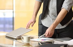 Close up of a businessman hands leaving work and closing laptop at office