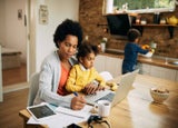 Mum working from home looking after kids and balancing work responsibilities.