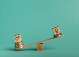 Gender pay gap. Wooden cubes with male and female gender signs on seesaw with different stacks of coins, men outweigh, copy space