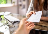Person giving a cheque to their colleague