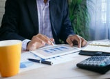 Man sitting at a desk looking at data on a tablet