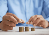 Person counting coins into piles