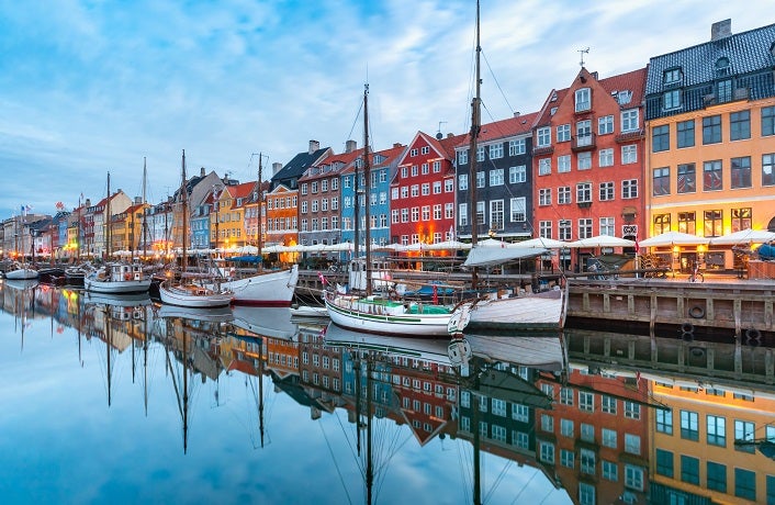 Nyhavn with colorful facades of old houses and old ships in the Old Town of Copenhagen, capital of Denmark.