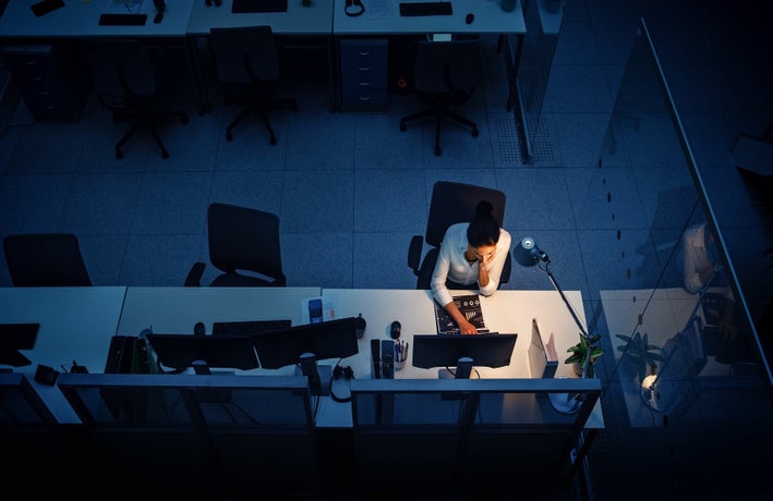 Introverted leader sat behind the desk alone at night