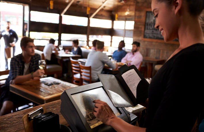 Restaurant staff member preparing a bill