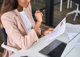 A woman at a desk looking at a candidate's CV
